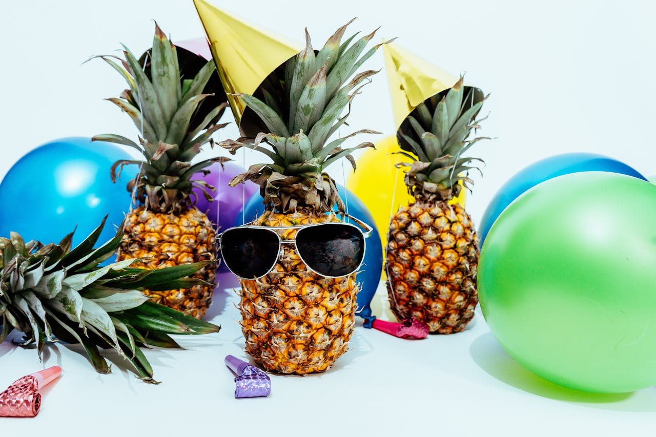 services-02 Fun tropical-themed party featuring pineapples with sunglasses and colorful balloons.